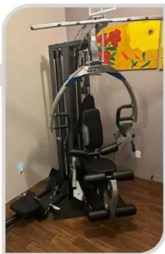 Modern fitness mobility machine with adjustable arms and a curved arm, displayed on a wooden floor (no visible text or symbols)
