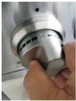 Close-up of a hand holding a metallic kitchen brush (no visible text or symbols)
