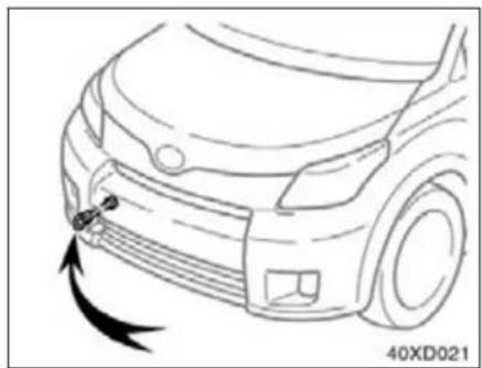 Line drawing of a car's front bumper with a curved arrow indicating motion or force (no text or symbols)