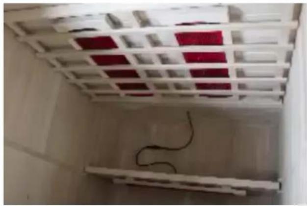 Interior view of a white lattice room with red and black panels, no visible text or symbols