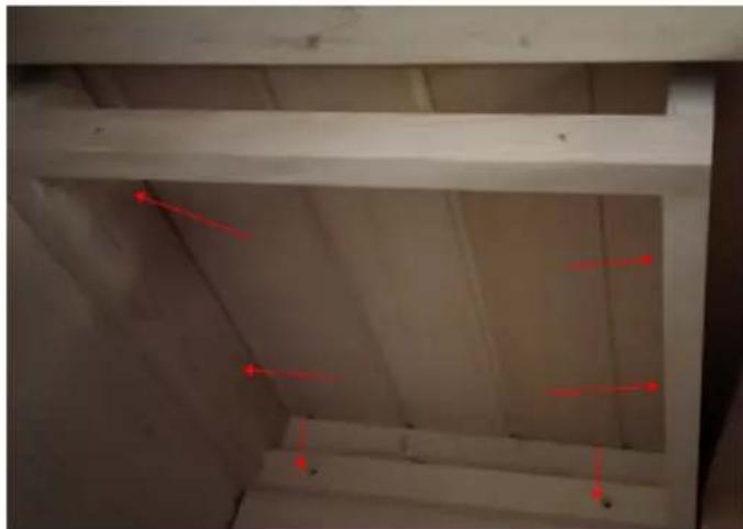Interior view of a concrete structure with red directional arrows indicating movement or force (no text or symbols)