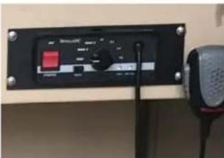 Control panel with digital display and speaker, showing a red button and text labels