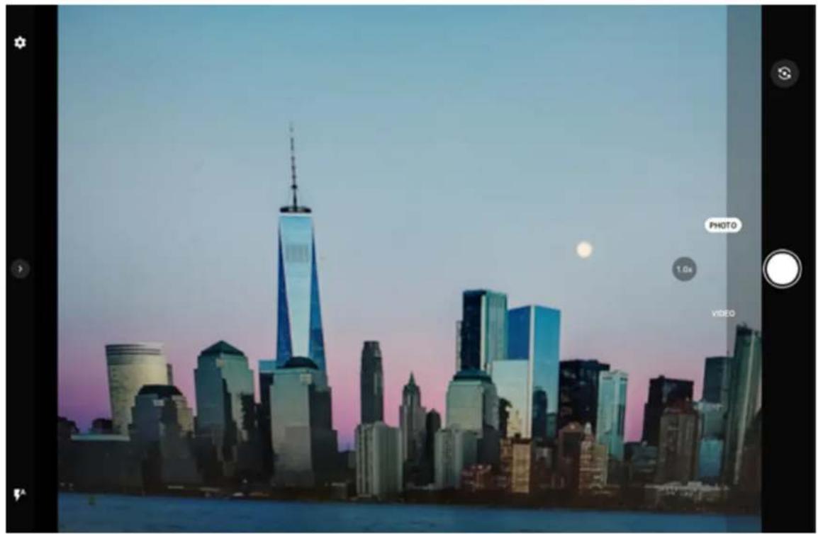 City skyline at dusk with a prominent skyscraper and a full moon visible in the sky (no text or symbols on buildings)