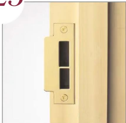 Close-up of a wooden door lock with two black rectangular buttons and circular buttons, mounted on a beige wall (no text or symbols visible)