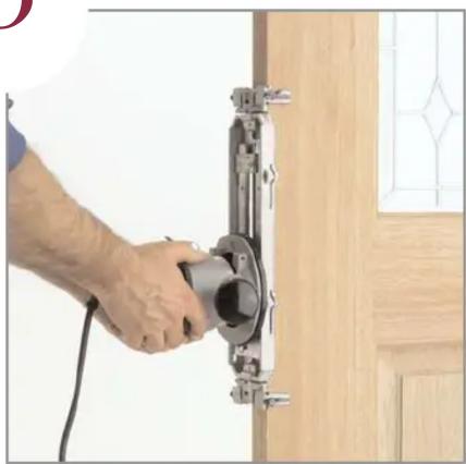 Person using a tool to install a wall-mounted component, no visible text or symbols