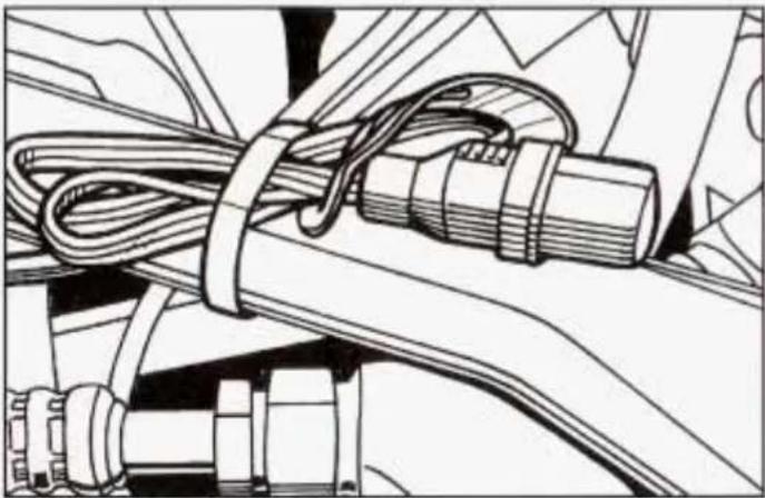Technical line drawing of a mechanical assembly with coiled cable and connectors (no text or symbols)