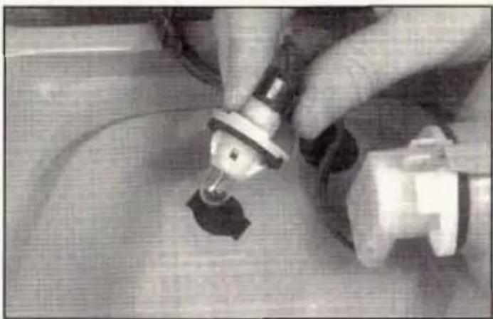 Close-up of hands using a tool to adjust or install a component, no visible text or symbols