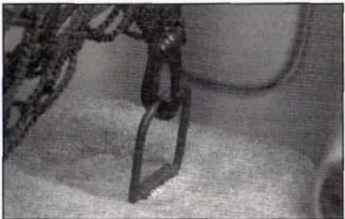 Close-up of a mechanical device with a chain and lever mechanism (no visible text or symbols)
