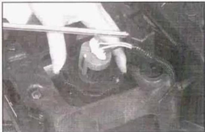 Close-up of a person using a tool on a mechanical component, no visible text or symbols