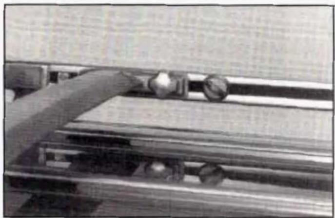 Black-and-white photo of a person lying on a wooden bench with a small object, no visible text or symbols