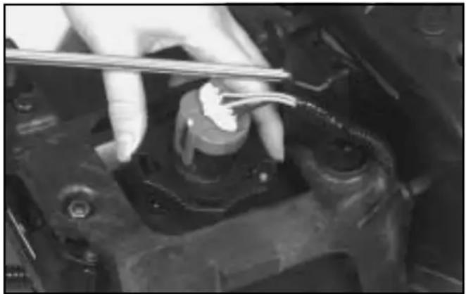 Close-up of a hand using a tool to adjust or install a mechanical component (no visible text or symbols)