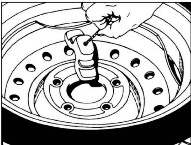 Line drawing of a hand using a tool to adjust or install a car tire component (no text or symbols present)