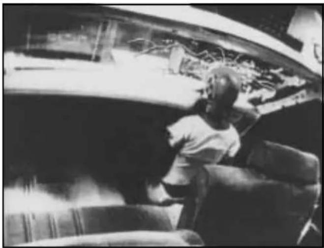 Black-and-white photo of a person sitting on a vehicle, viewed from above (no visible text or symbols)
