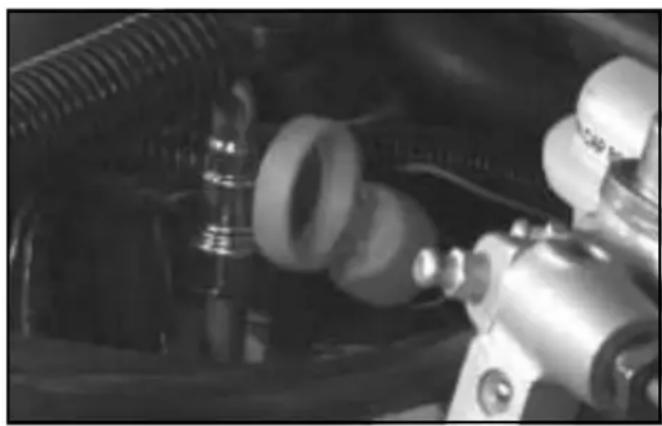 Close-up of mechanical components including hoses and a motor (no visible text or symbols)