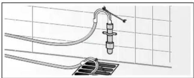 Technical diagram of a piping system with two valves and a drain, mounted on a grid-patterned surface (no text or symbols)