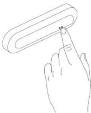 Line drawing of a hand holding a cylindrical object with a small mark on the tip (no text or symbols)