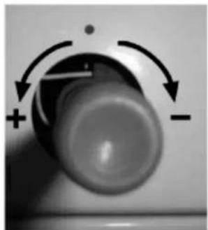 Close-up of a mechanical knob with directional arrows indicating rotation (no text or symbols)