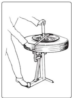 Illustration of a person using a cart to lift a wheel, no text or symbols present