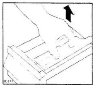 Line drawing of a hand pressing down on a mechanical component (no text or symbols)