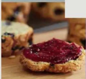 Close-up of a baked pastry with red jam, served on a wooden surface (no text or symbols visible)