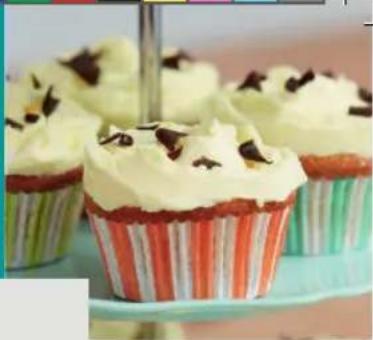 Close-up of cupcake contains white cream with chocolate toppings, arranged on a patterned stand (no text or symbols visible)