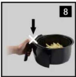 Hand holding a black air fryer with a knife, no text or symbols visible