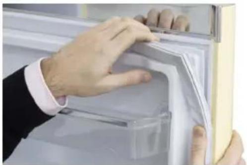 Close-up of hands installing or adjusting a door panel on a refrigerator (no visible text or symbols)