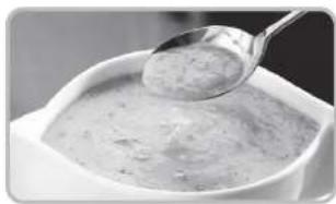 Close-up of a spoon lifting a creamy mixture in a white bowl (no text or symbols visible)