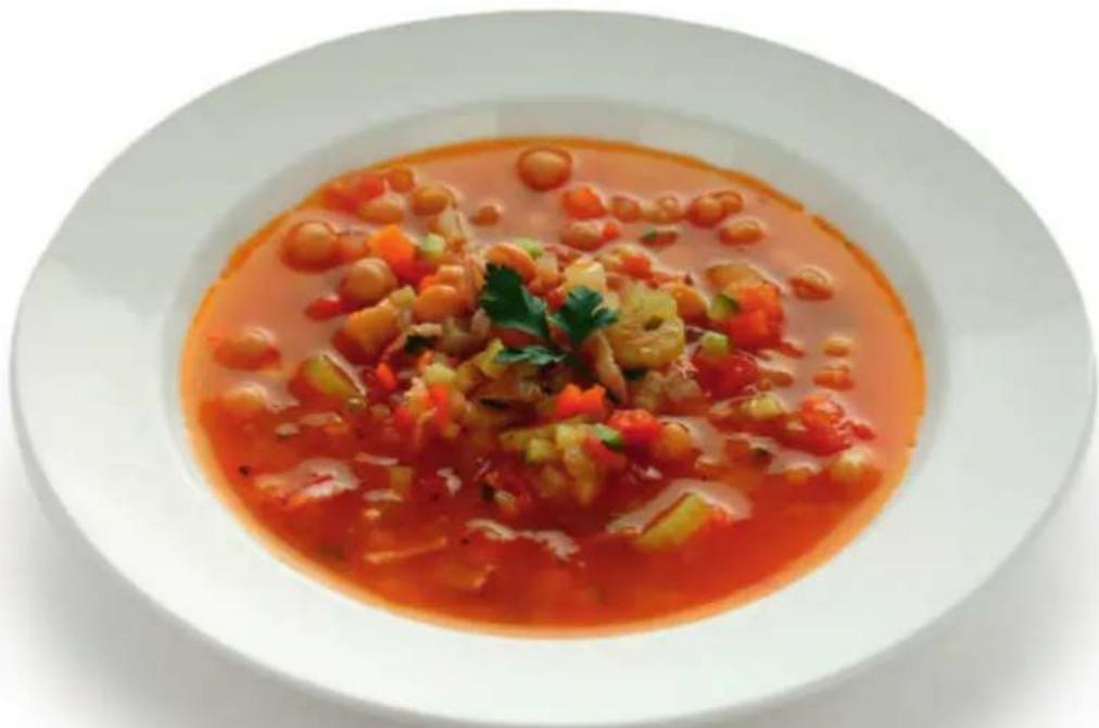 Bowl of tomato sauce with visible vegetable overlays and garnish (no text or symbols)