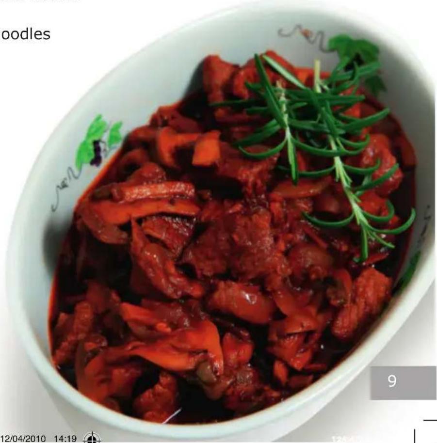 Close-up of a bowl of cooked meat with red sauce and green herbs, no visible text or symbols