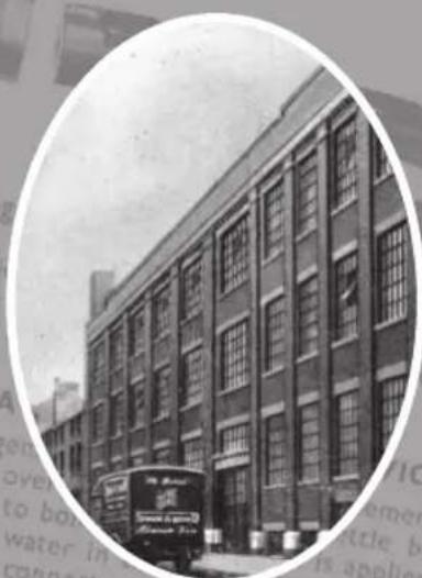 Exterior view of a multi-story brick building with adjacent street traffic and a vintage bus (no visible text or signage)
