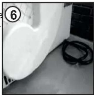 Interior view of a room with a white plastic wall and black cables on the floor (no visible text or symbols)