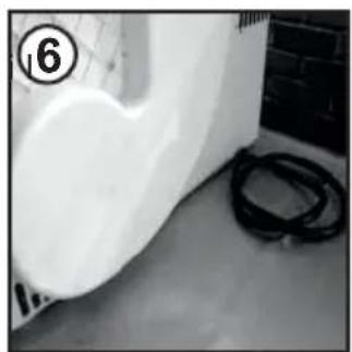 Close-up of a white industrial component with a coiled cable, placed on a surface near a brick wall (no visible text or symbols).