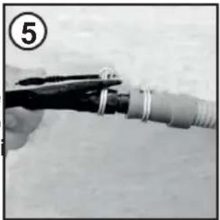Close-up of a hand holding a tool with a coiled cable or wire.