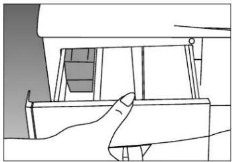 Line drawing of a hand holding a small object, possibly a device or machine component (no text or symbols visible).