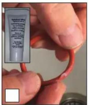 Close-up of a hand holding a red tube with a small inset showing a labeled container containing text and formulas.