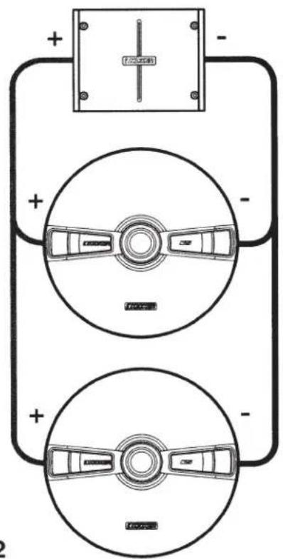 Diagram showing two circular components with labeled car wheels and a battery, connected by polarity indicators.