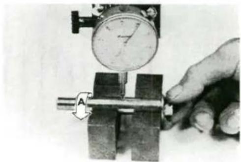 Close-up of a hand using a pressure gauge to measure a mechanical component (no visible text or symbols)