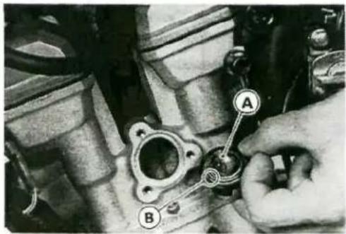 Mechanical component diagram with labeled parts A and B, showing a hand operating a valve or actuator.