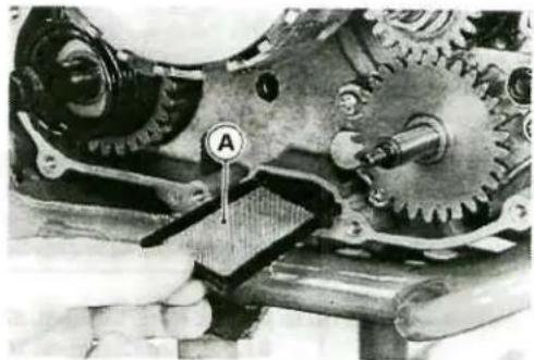 Close-up of mechanical gears and a clamped component being inserted, no visible text or symbols