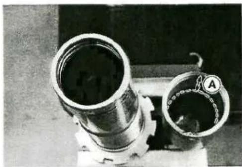 Close-up of two metallic pipe fittings with a labeled component (A) and no visible text or symbols.