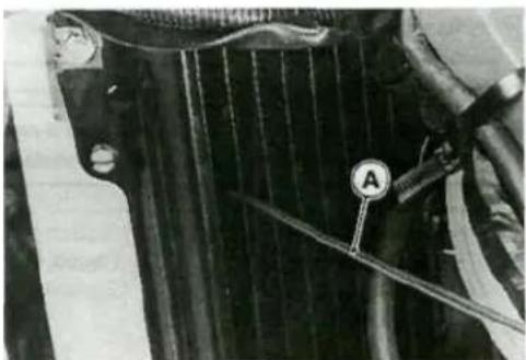 Close-up of a car radiator panel with a labeled sensor (A) and tool, no visible text or symbols beyond the label.