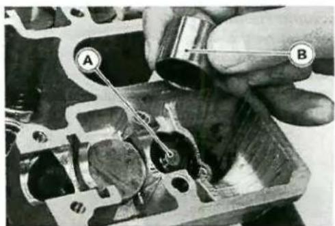 Close-up of a hand using a tool to adjust internal components in an engine cylinder (no visible text or symbols)