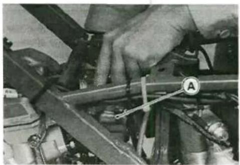 Close-up of a hand adjusting automotive engine components (no visible text or symbols)