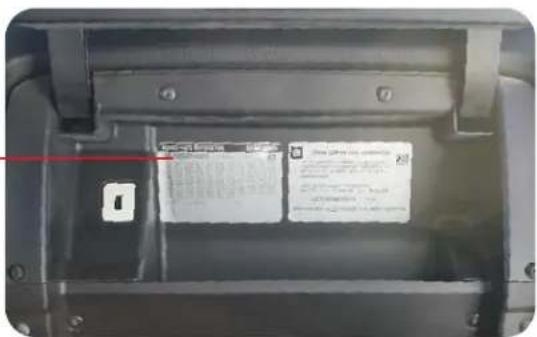 Close-up of a device casing with visible battery label and red warning arrow indicating safety warnings