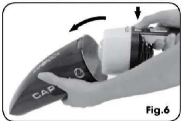 Close-up of a hand using a camera to lift a cap, showing the blade and handle (no text or symbols visible)