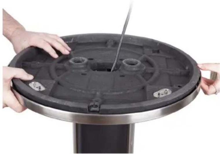 Close-up of hands installing or adjusting a circular mechanical component with a handle (no text or symbols visible)