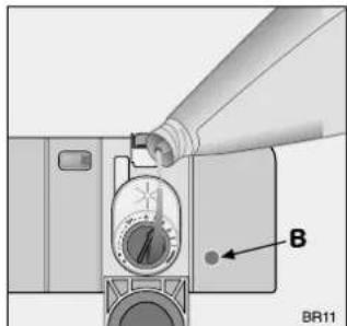 Diagram of a mechanical device with a bottle pouring liquid into a container, labeled B (no text or symbols beyond label).