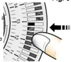 Close-up of a hand holding a circular gauge with numbered markings and directional arrows indicating measurement or navigation.