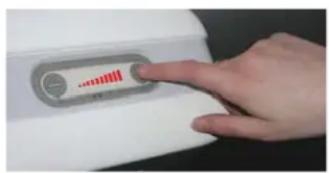 Hand pressing a button on a white electronic device with a red indicator and waveform display